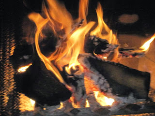 Burning logs in a fireplace, bright flames.