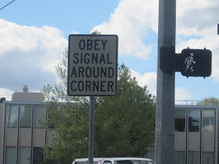 Sign reads "Obey Signal Around Corner".