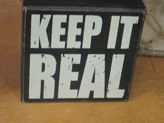 Sign with "Keep It Real" text.