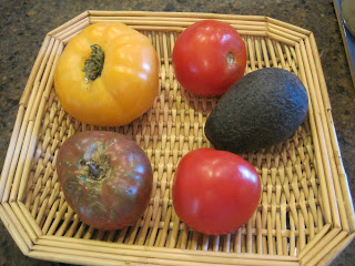 Basket with tomatoes and an avocado.