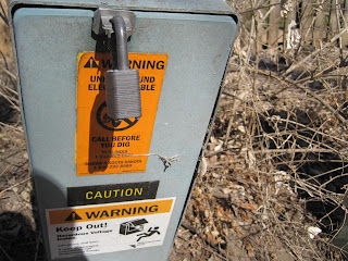 Utility box with warning labels and lock.