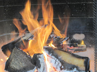 Burning logs in a fireplace with flames.