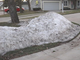 Dirty snow pile on suburban street corner.