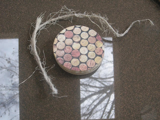 Circular cork coaster with twine on table.