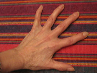 Hand on colorful striped fabric background.