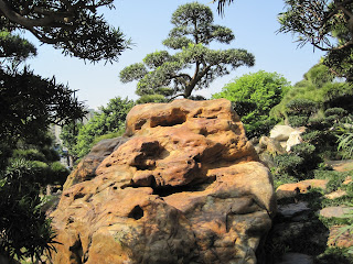 Rock formation with tree and greenery background.