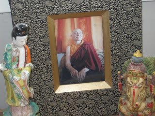 Framed portrait with two decorative statues.