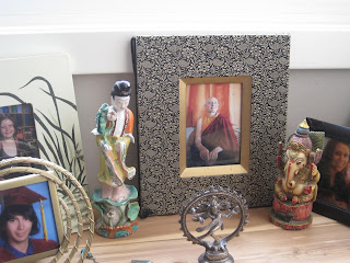 Framed photos and figurines on a shelf.