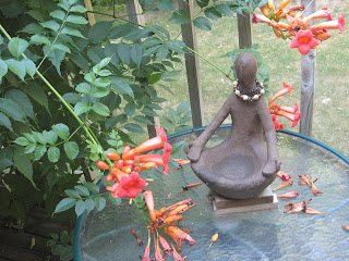 Statue with flowers on a glass table.
