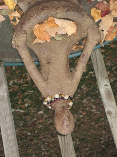 Rustic sculpture with autumn leaves surrounding it.