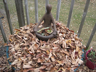 Statue surrounded by autumn leaves on deck.