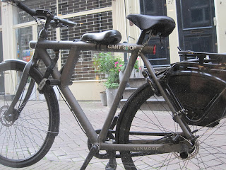 Black bicycle parked on city street.