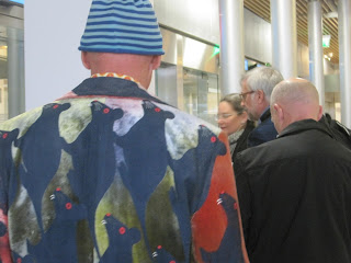 Man wearing colorful jacket and striped hat.