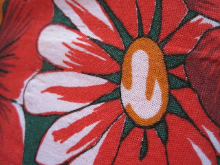Red and white floral fabric pattern close-up.