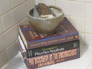 Books stacked with a bowl on top.