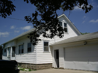 White house with garage under blue sky.