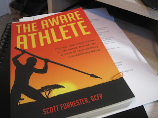 Book titled "The Aware Athlete" on table.