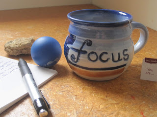 Mug with "focus" text, pen, and ball.