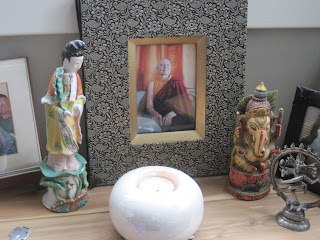 Decorative items and framed portrait on shelf.