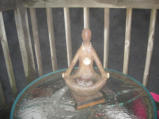 Wooden sculpture on glass table outdoors.