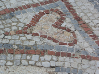 Heart-shaped mosaic with red and gray stones.
