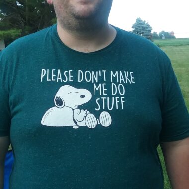 Person wearing a humorous Snoopy T-shirt about avoiding tasks.